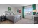 Cozy bedroom with neutral walls, carpet, and a large window with bright green curtains at 2323 Riggs Rd, Sherrills Ford, NC 28673