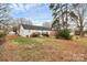 A spacious backyard with a grassy lawn, mature trees, and a view of the house with two decks at 307 W Mcneely Ave, Mooresville, NC 28115