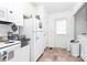 Kitchen with white appliances and cabinetry with exterior door and tile floor at 307 W Mcneely Ave, Mooresville, NC 28115