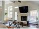 Bright living room featuring a cozy fireplace, modern lighting, and natural light from windows at 3516 Mill Stream Ct, Charlotte, NC 28209