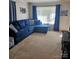 Living room with a large blue sectional sofa, patterned ottoman, and a large window for natural light at 5516 Northwood Dr, Hickory, NC 28601