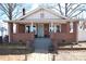 Charming brick home featuring a covered front porch with brick columns and a light blue front door at 604 Pearl Ave, Kannapolis, NC 28083