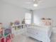 Bright bedroom featuring a ceiling fan, a bed with polka dots, and toys and stuffed animals at 605 Lumber Ln, Charlotte, NC 28214