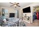 Well-lit bedroom with a large bed, closet, and a television with decor on shelving at 6830 Colonial Garden Dr, Huntersville, NC 28078