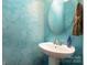 Stylish half bathroom with a pedestal sink, decorative mirror, and chic lighting at 6830 Colonial Garden Dr, Huntersville, NC 28078