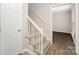 Entryway with a carpeted staircase, white railings, and wood grain floors at 8137 Sheringham Way, Charlotte, NC 28227