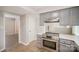 Kitchen view with gray cabinets, stainless steel oven, and wood grain flooring at 8137 Sheringham Way, Charlotte, NC 28227