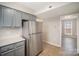 Kitchen featuring gray cabinets and stainless steel refrigerator near a doorway to another room at 8137 Sheringham Way, Charlotte, NC 28227