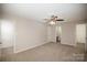 This main bedroom features a ceiling fan, carpet floors, and doorways to the bathroom and closet at 8137 Sheringham Way, Charlotte, NC 28227