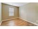 Neutral bedroom with wood-look floors and a large window for natural light at 830 Wilcrest Ct, York, SC 29745