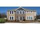 Beautiful home exterior featuring large windows, stone accents, and lush landscaping at 9020 Northfield Crossing Dr, Charlotte, NC 28269