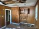 Room featuring wood paneling, a hole in the ceiling, and an open shelf at 909 Gibbons St, Gastonia, NC 28052