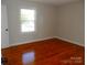 Bright bedroom featuring hardwood floors, a window, and neutral wall paint at 101 Colony Acres Dr, Charlotte, NC 28217