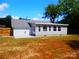 Well-maintained exterior view of home with sunroom, white trim and a spacious, sunny yard at 101 Colony Acres Dr, Charlotte, NC 28217
