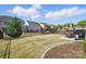 Large, fenced backyard with lush lawn, play set, patio dining set, and manicured landscaping at 108 Hillston Ln, Mooresville, NC 28115
