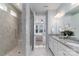 Well-lit bathroom features a tiled shower with bench and double vanity with granite countertops at 108 Hillston Ln, Mooresville, NC 28115