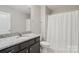Elegant bathroom featuring granite countertop, under-sink cabinetry, and a shower with white curtain at 108 Hillston Ln, Mooresville, NC 28115
