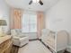 Lovely Bedroom with soft colors, crib, and cozy chair, perfect for a new baby at 108 Hillston Ln, Mooresville, NC 28115