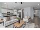 Open-concept living room with white sofas flows into bright kitchen and dining spaces at 108 Hillston Ln, Mooresville, NC 28115