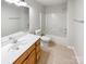 Bright bathroom featuring tile floor, a light wood vanity and shower tub combination at 12025 Willingdon Rd, Huntersville, NC 28078