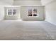 Spacious bedroom with tray ceiling, carpet flooring and plenty of natural light from large windows at 12025 Willingdon Rd, Huntersville, NC 28078