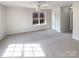 Large primary bedroom featuring neutral carpet, a ceiling fan and a view to the wooded backyard at 12025 Willingdon Rd, Huntersville, NC 28078