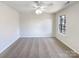 Bedroom with a ceiling fan, neutral walls, and a large window offering natural light at 12025 Willingdon Rd, Huntersville, NC 28078