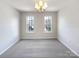 Cozy bedroom with gray carpet, neutral walls, and natural light from large windows at 12025 Willingdon Rd, Huntersville, NC 28078