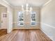 Bright dining room featuring beautiful hardwood floors, elegant lighting, and natural light from two windows at 12025 Willingdon Rd, Huntersville, NC 28078