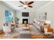 Bright living room featuring hardwood floors, a fireplace, and large windows with natural light at 12025 Willingdon Rd, Huntersville, NC 28078