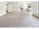 Bright main bedroom featuring neutral carpeting, tray ceiling, and ample natural light from large windows at 12025 Willingdon Rd, Huntersville, NC 28078