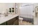 Bathroom with a white marble-look vanity, neutral paint, and combination shower/tub featuring a gray and white curtain at 1203 Kingsman Nw Ln, Concord, NC 28027