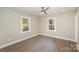 Spacious bedroom features wood floors, a ceiling fan, and two windows for natural light at 1208 Fordham Rd, Charlotte, NC 28208