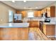 Modern kitchen with stainless steel appliances, wood cabinets, and a breakfast bar island at 12906 Sickles Dr, Charlotte, NC 28273
