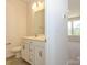 Modern bathroom featuring double sink vanity with mirror and view of the adjacent living area at 1311 Cerium Way, Charlotte, NC 28211
