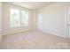 Bright bedroom featuring two windows offering outside views and neutral carpet at 1311 Cerium Way, Charlotte, NC 28211