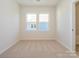 Bright bedroom showcasing plush carpet flooring and well-lit windows offering an airy atmosphere at 1311 Cerium Way, Charlotte, NC 28211