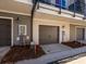 Townhome garages featuring a dark brown metal door at 1311 Cerium Way, Charlotte, NC 28211