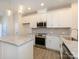 Modern kitchen with stainless steel appliances, granite counters, white cabinetry, and pendant lights at 1311 Cerium Way, Charlotte, NC 28211