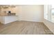 Open floor plan featuring hardwood floors, a modern kitchen, and abundant natural light from large windows at 1311 Cerium Way, Charlotte, NC 28211