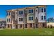 View of new construction townhomes featuring brick facade, modern design, and green lawn at 1311 Cerium Way, Charlotte, NC 28211