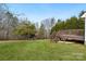 View of backyard featuring a wooden deck with stairs, mature trees and lush green grass at 158 Angel Oaks Dr, Statesville, NC 28677