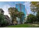 Upscale high-rise condo building with a glass exterior and lush green landscaping at 210 N Church St # 3606, Charlotte, NC 28202