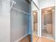 Well-organized closet with wire shelving and mirrored doors leading into the bathroom at 210 N Church St # 3606, Charlotte, NC 28202
