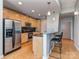 Modern kitchen with stainless steel appliances, wood cabinets, and a granite countertop breakfast bar at 210 N Church St # 3606, Charlotte, NC 28202