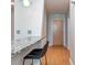 Compact kitchenette featuring a granite countertop bar with a black leather stool and hardwood floors at 210 N Church St # 3606, Charlotte, NC 28202