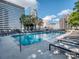 Sparkling swimming pool surrounded by lounge chairs, set against a backdrop of city skyline at 210 N Church St # 3606, Charlotte, NC 28202