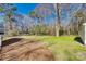Lush green backyard featuring a spacious lawn area with a partial view of a home in the distance at 2478 Stribling Cir, Lancaster, SC 29720