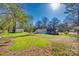 Expansive grassy backyard featuring mature trees and the house in the distance, providing a peaceful outdoor view at 2478 Stribling Cir, Lancaster, SC 29720