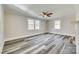 A bright, empty room with hardwood floors, ceiling fan, large windows and modern trim, ready for personalization at 2478 Stribling Cir, Lancaster, SC 29720